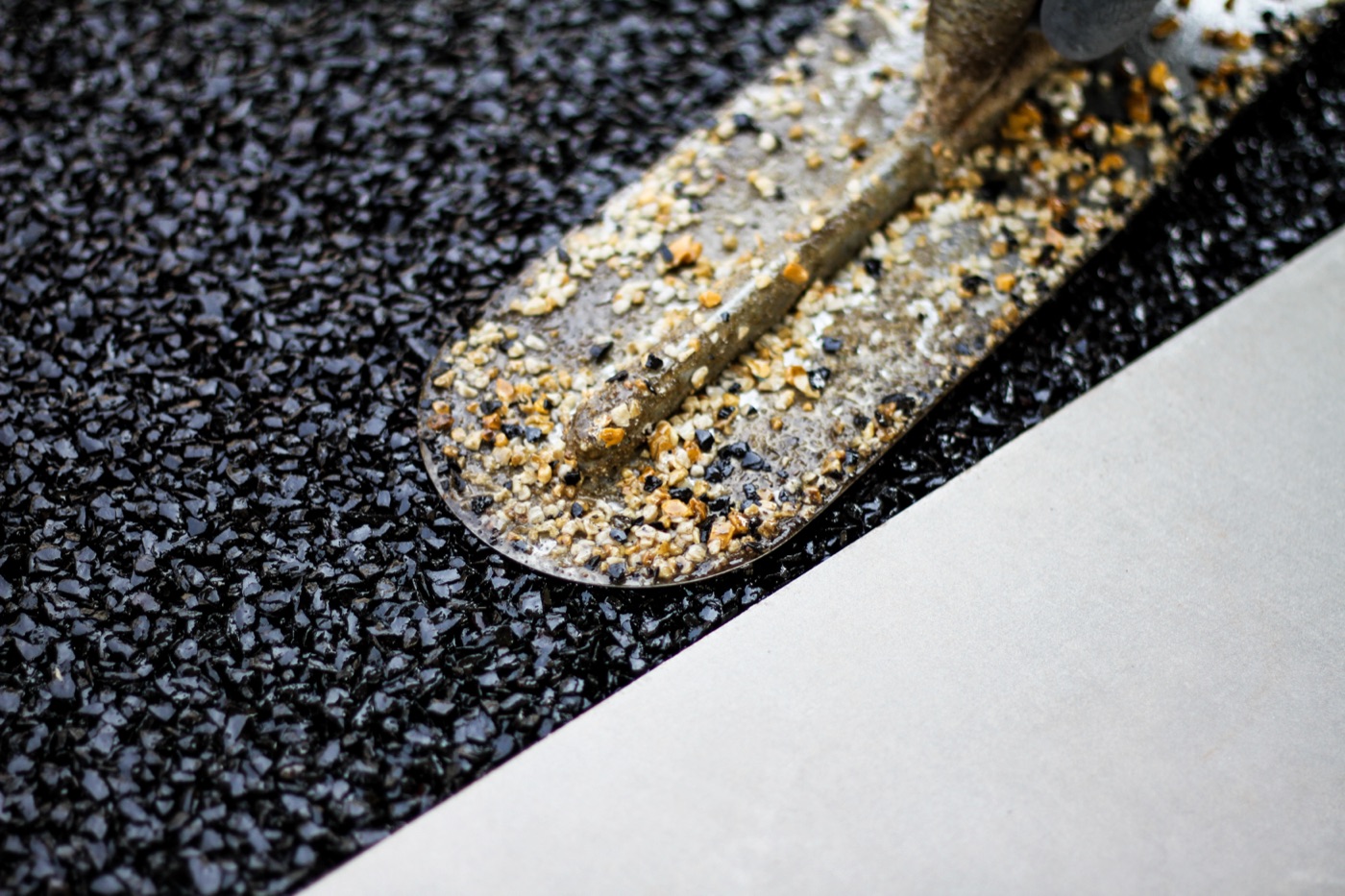 Resin bound stone close-up — dark pebble texture